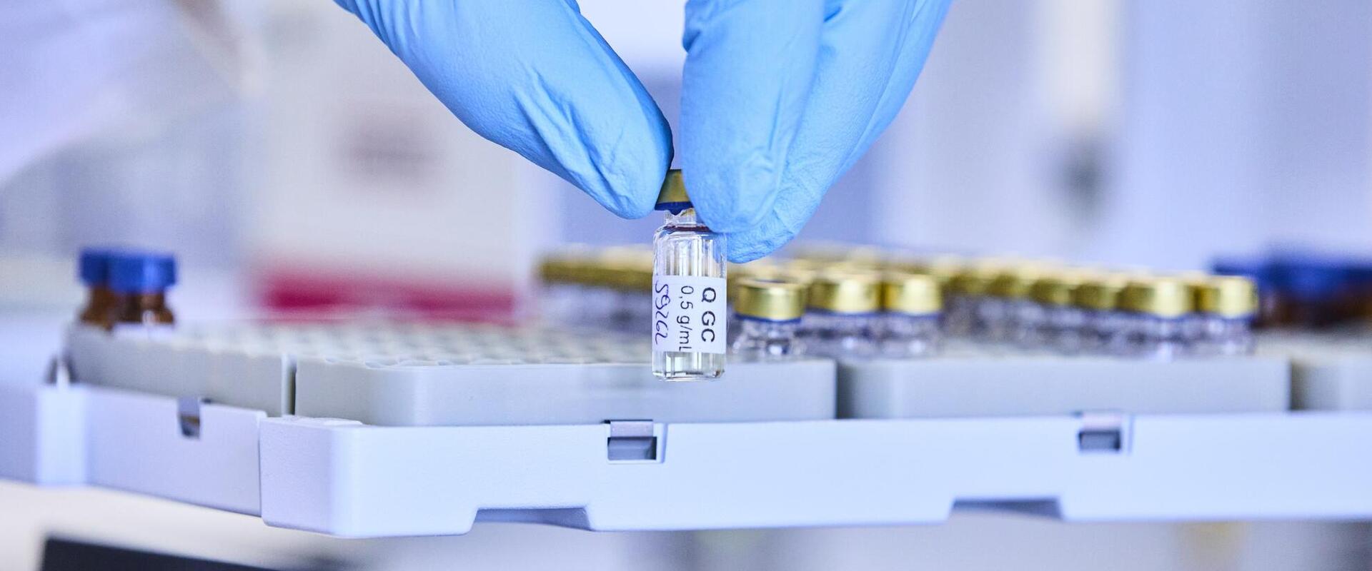A GC vial is removed from an autosampler